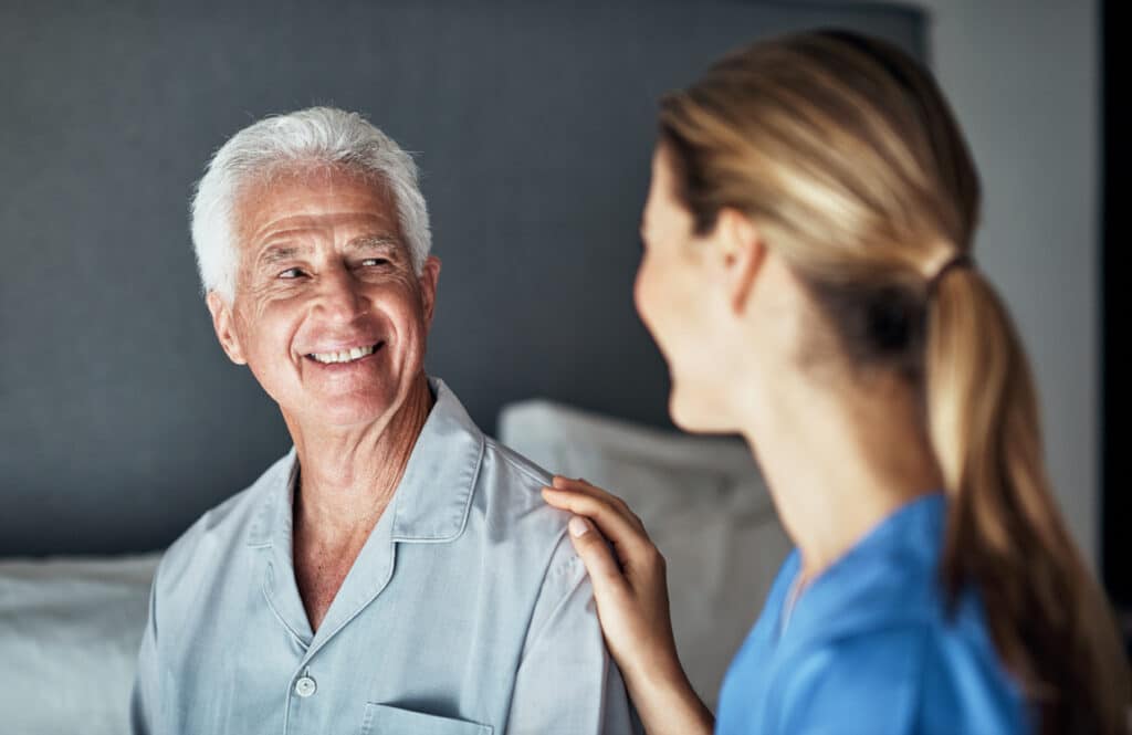 older man speaking with a healthcare provider during a medical visit