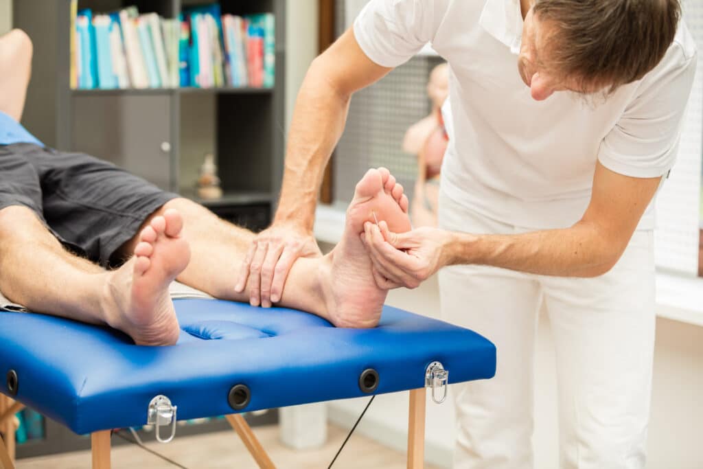 A  doctor, testing the sensibility  of a patient`s foot. This test is often used for checking neuropathy of diabetic patients. XXXL size image.
